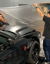Black Dodge Challenger getting vinyl wrap installation