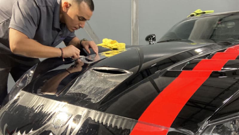 AZ Auto Aesthetics Team Member Installing Clear Bra On Black Car Near Tempe